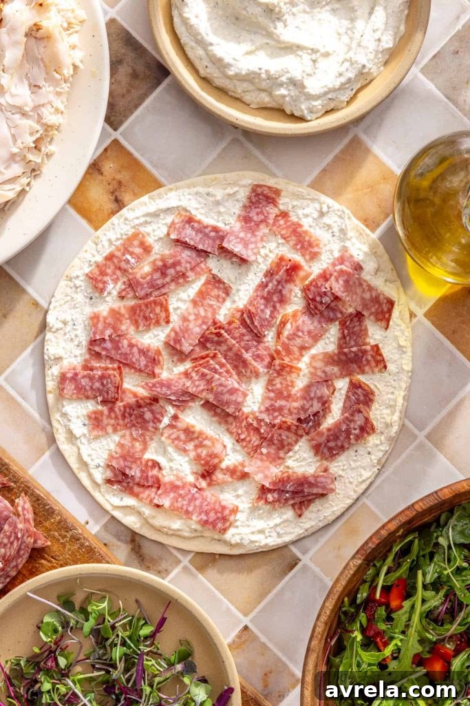 Diced salami sprinkled over cottage cheese spread on tortilla