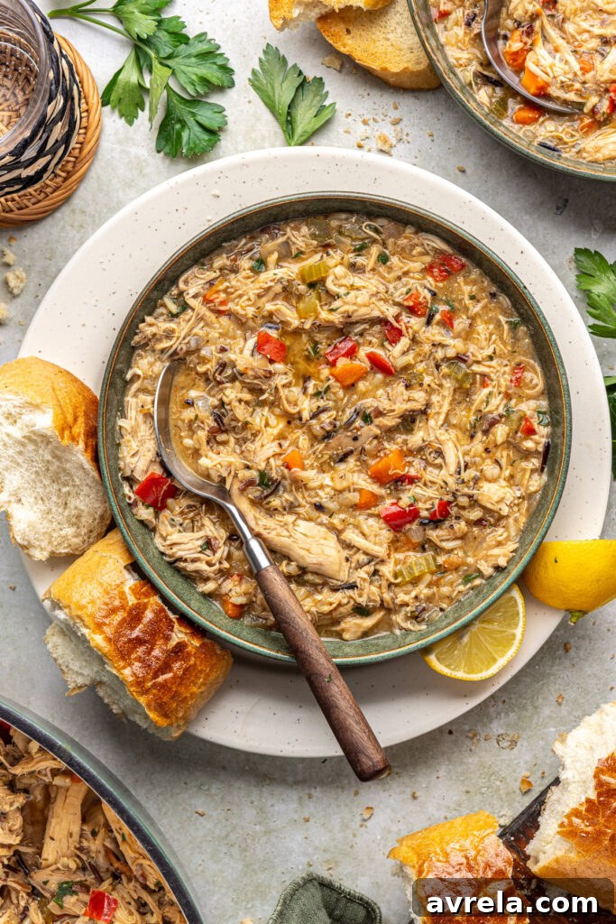 Creamy dairy-free cajun chicken soup plated for dinner with toasted bread and lemon wedges