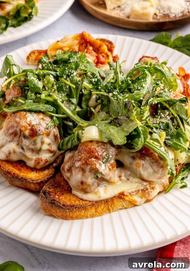 Open-faced, high-protein chicken pesto parmesan meatball subs with marinara sauce and melted cheese