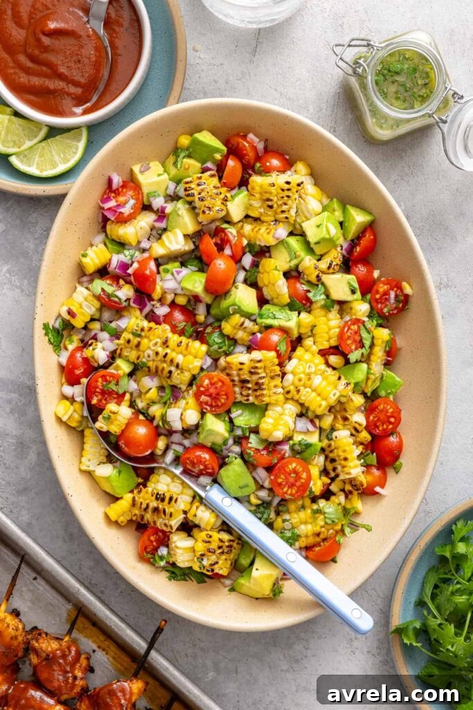 Fresh Corn and Tomato Summer Salad with Basil and Lime 8 Corn and tomato summer salad served in an oval bowl on a colorful table