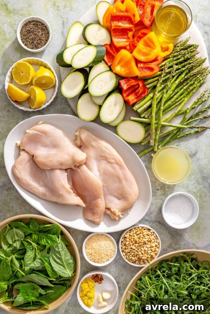 Ingredients for lemon pesto grilled chicken including chicken breasts, basil, pine nuts, lemons, zucchini, asparagus, bell peppers, garlic, Parmesan, and olive oil