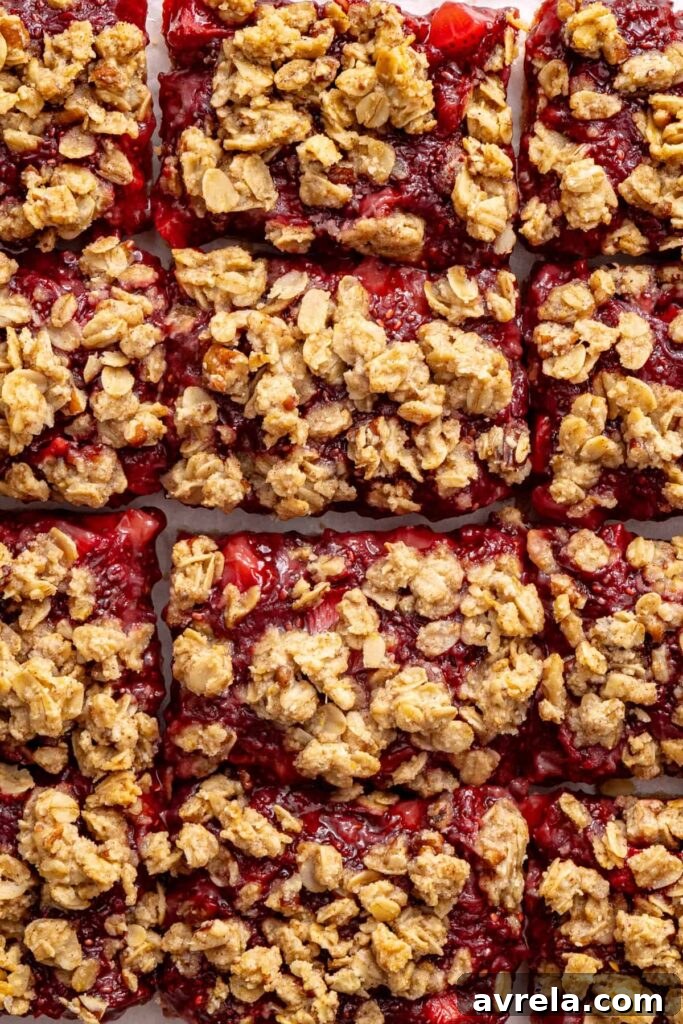 Close-up of sliced strawberry oatmeal bars with a buttery oat crumble topping.