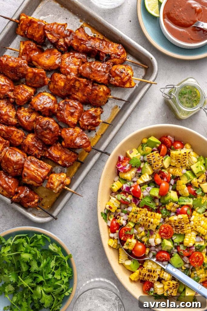 High-protein BBQ chicken skewers paired with fresh corn and tomato salad