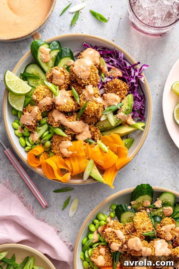 healthy air fryer bang bang shrimp bowls with colorful vegetables on a set table
