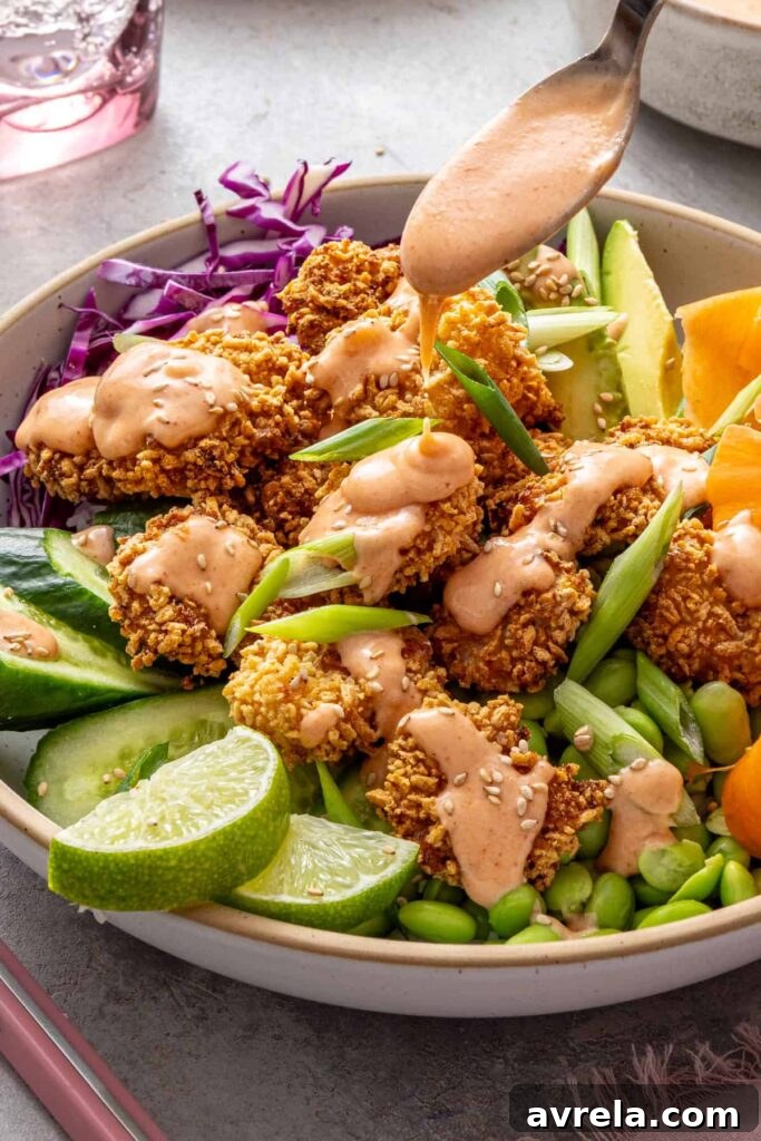 Fresh homemade bang bang sauce poured over healthy shrimp bowls.
