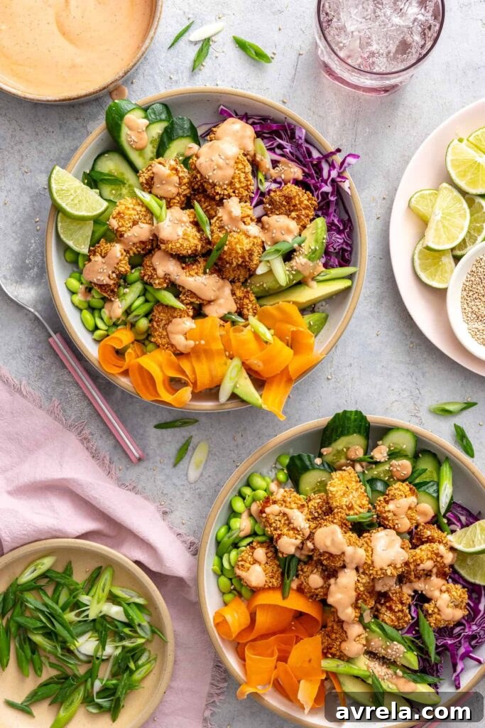 Overhead view of healthy air fryer bang bang shrimp bowls topped with a homemade, dairy-free bang bang sauce.