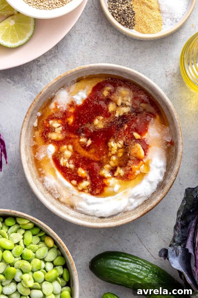 Making homemade bang bang sauce with coconut yogurt, honey, sriracha and garlic.