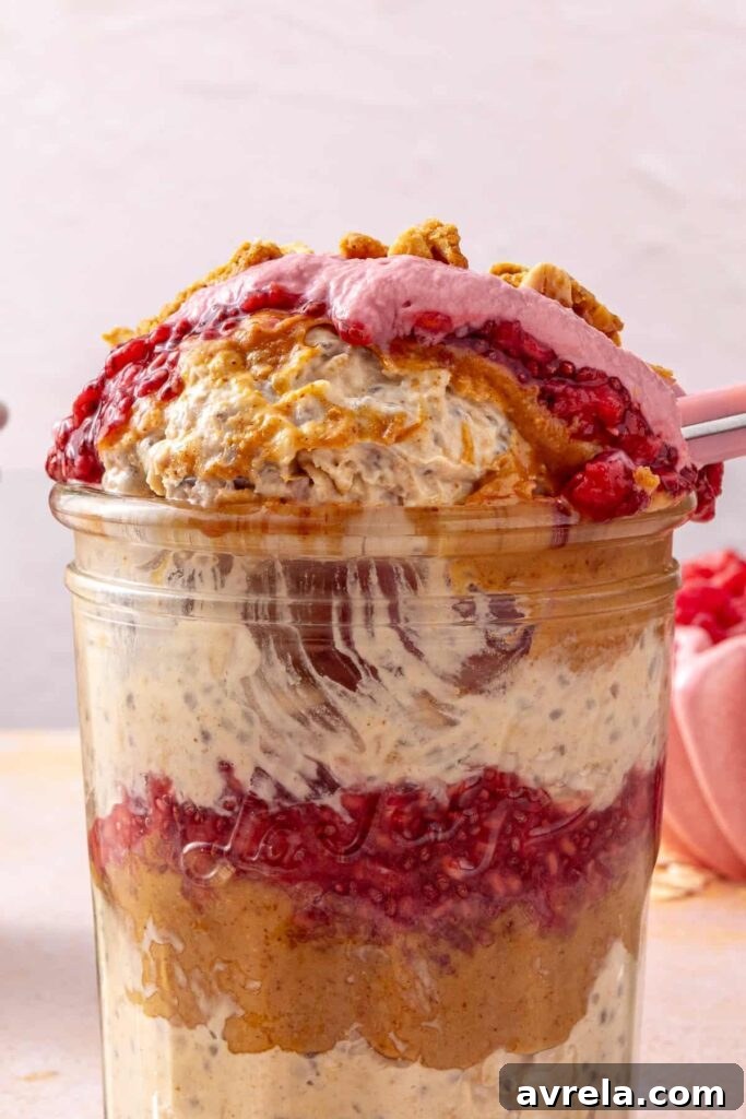 Bite of peanut butter and jelly overnight oats with raspberry yogurt topping