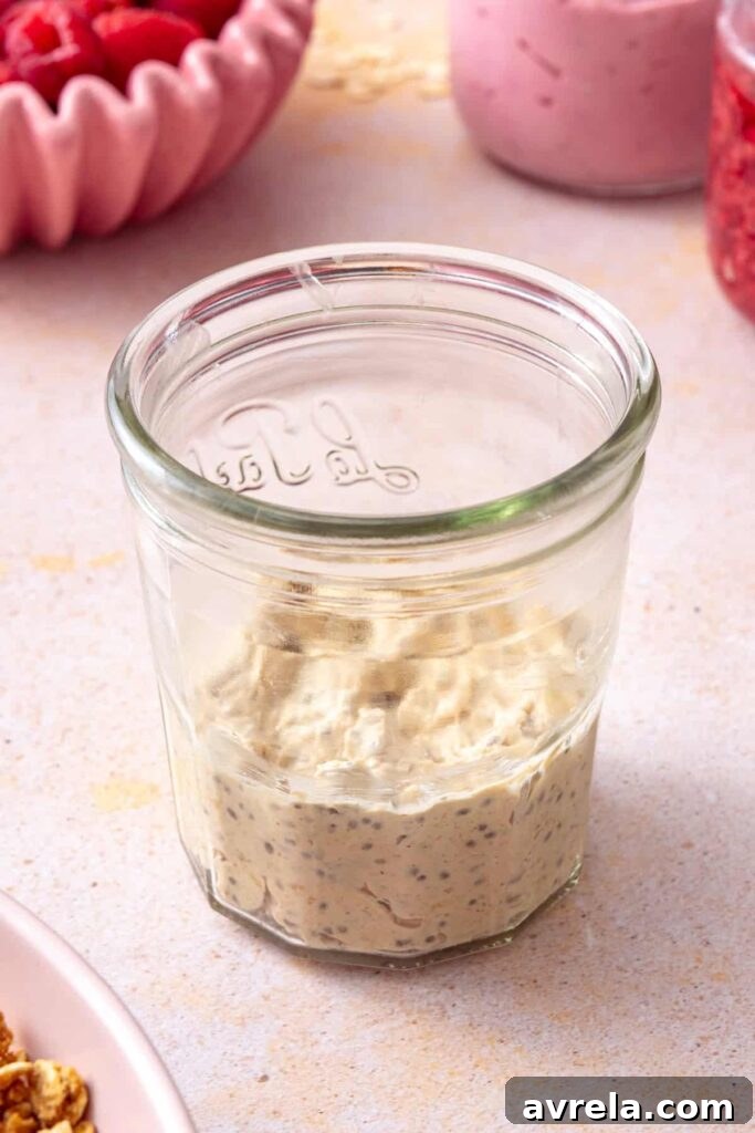 Building layers of overnight oats and homemade raspberry jam
