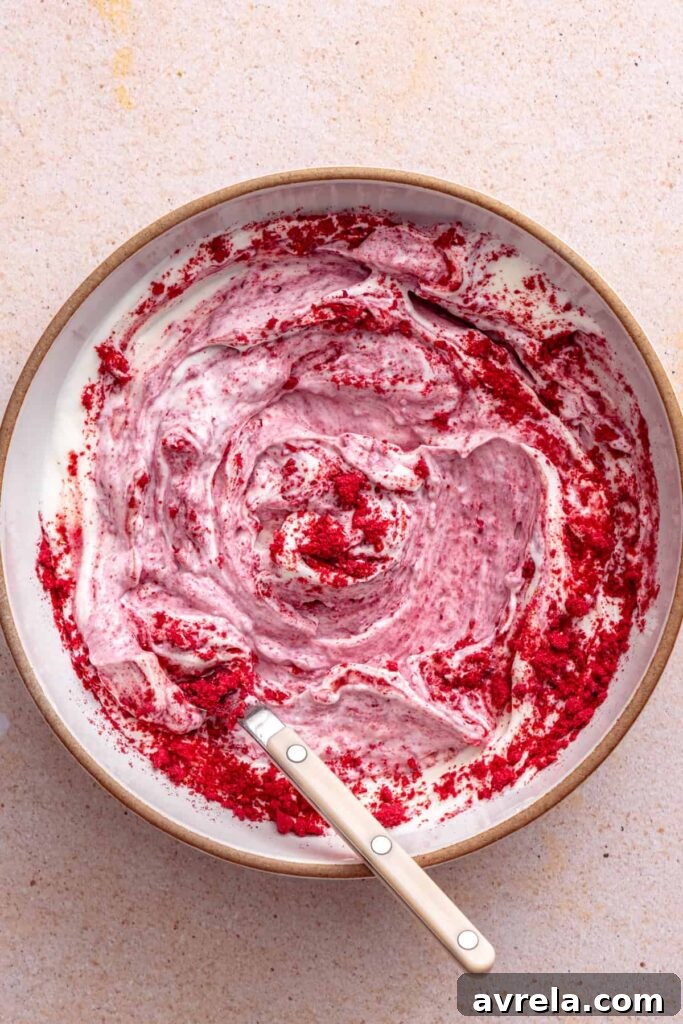 Raspberry Greek yogurt whipped topping being mixed until smooth