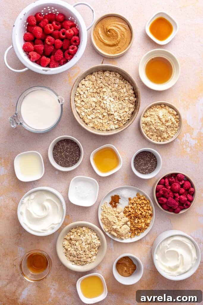 Ingredients for peanut butter and jelly overnight oats including oats, Greek yogurt, raspberries, chia seeds, peanut butter, PB2, and maple syrup