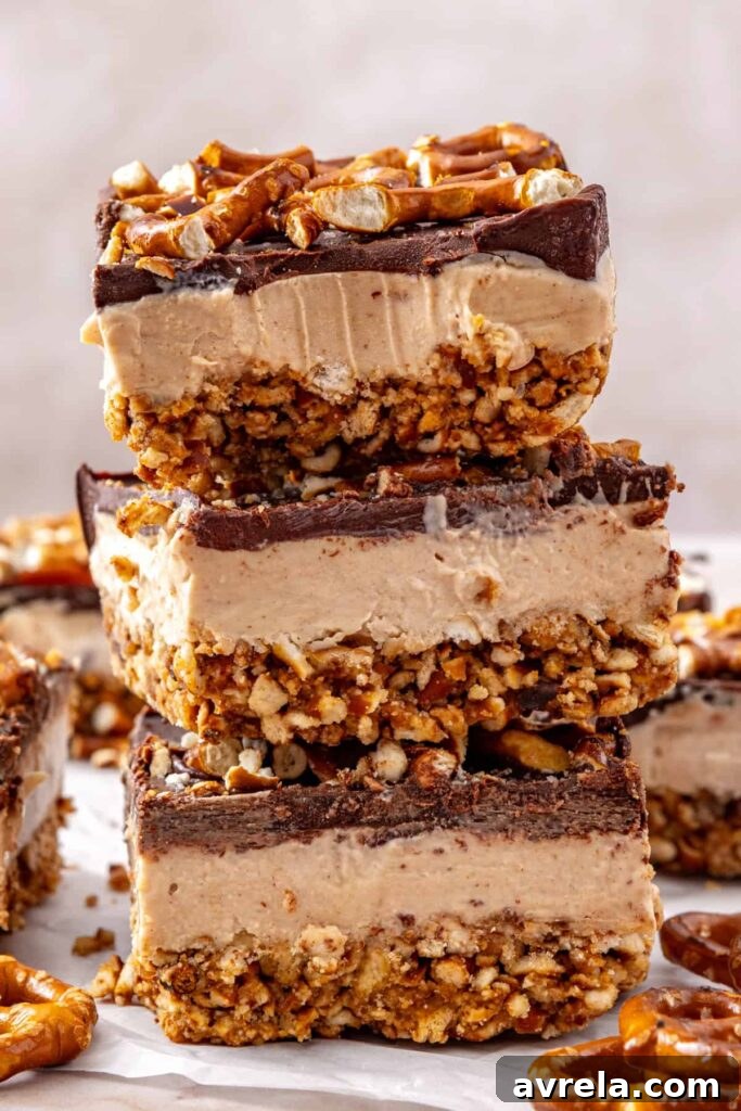 High-protein frozen peanut butter pretzel bars stacked on a serving table.