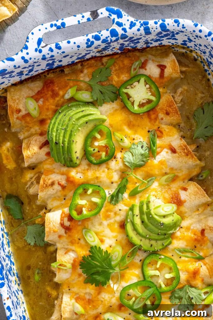 Baked Creamy Chicken Enchiladas with Salsa Verde 6 Close-up of garnished creamy green chicken enchiladas in a speckled baking dish