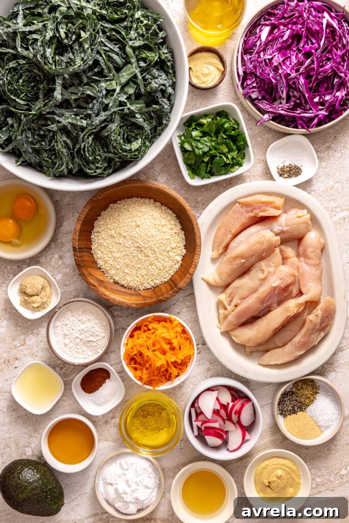 Overhead view of kale, chicken tenders, cabbage, carrots, radishes, and honey mustard ingredients
