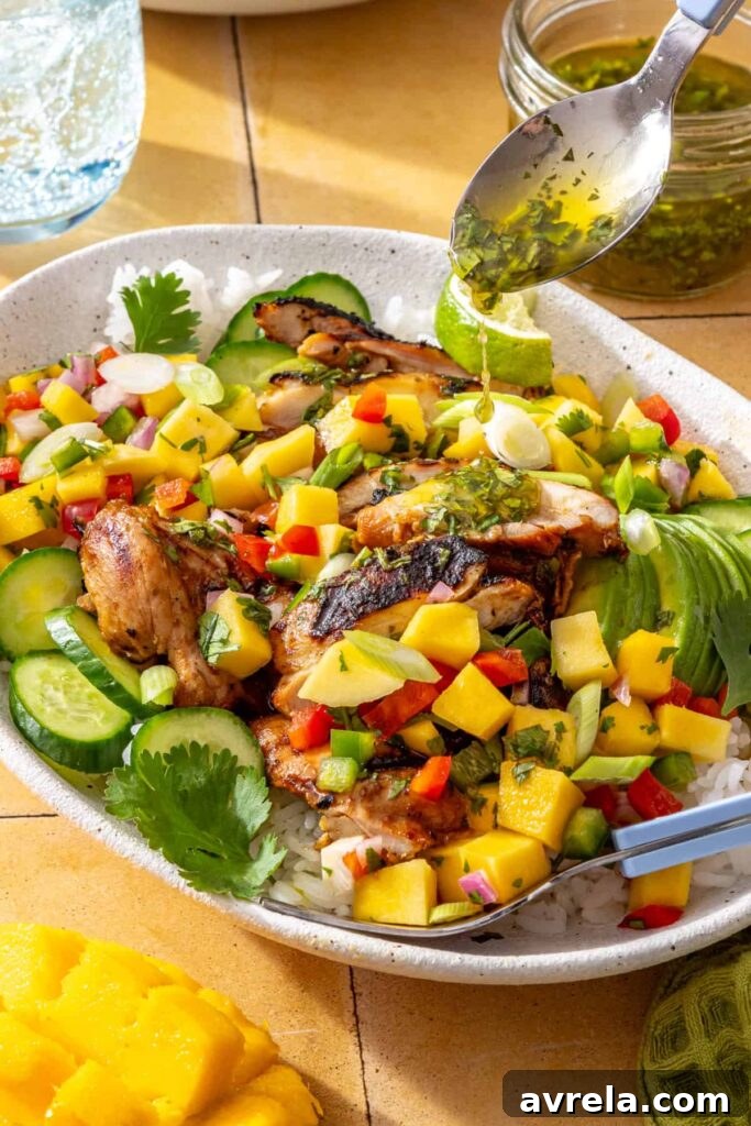 Fresh cilantro-lime drizzle poured over honey lime grilled chicken with mango salsa