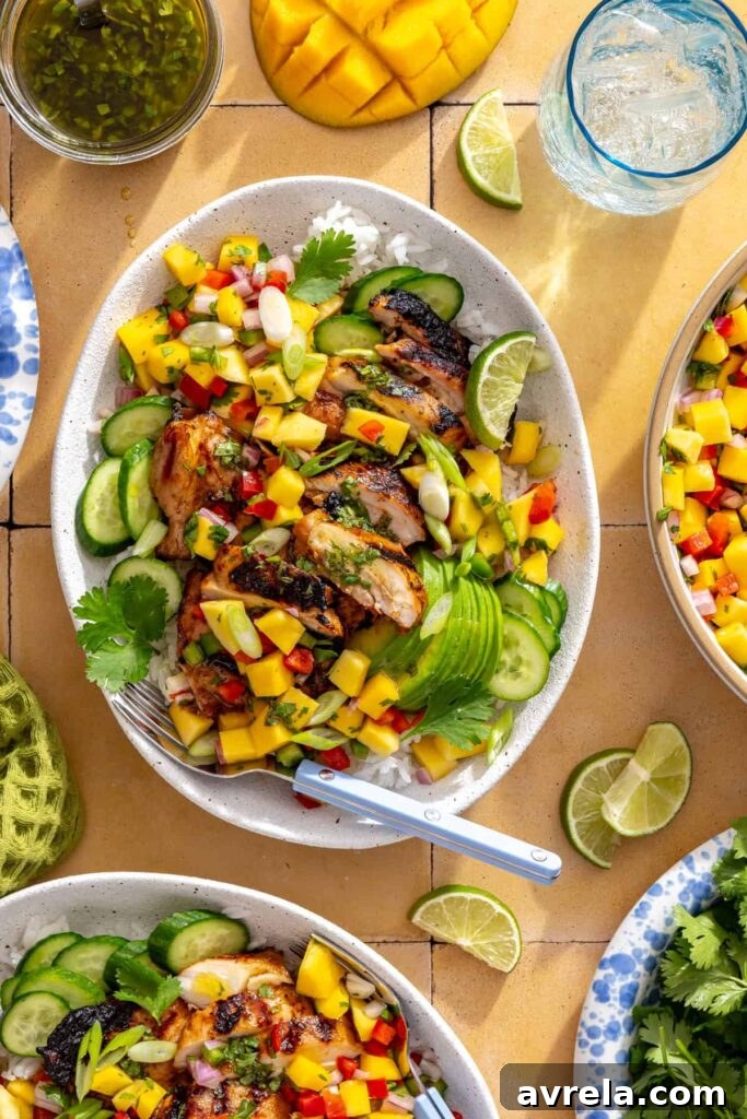 Honey lime grilled chicken served on a platter with mango salsa, cucumber, and lime wedges