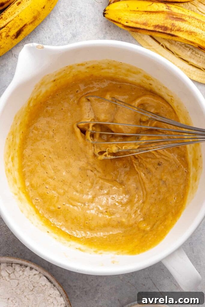 whisking mashed bananas, eggs and Greek yogurt for banana birthday cake