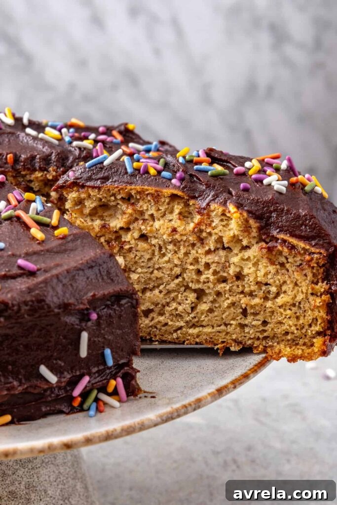 Healthy banana birthday cake slice lifted from cake stand