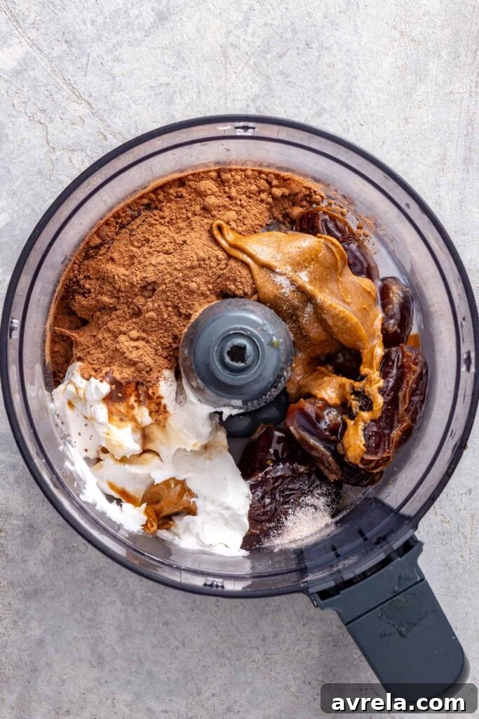 Dates, cacao powder, coconut cream, almond butter, vanilla, and sea salt in a food processor