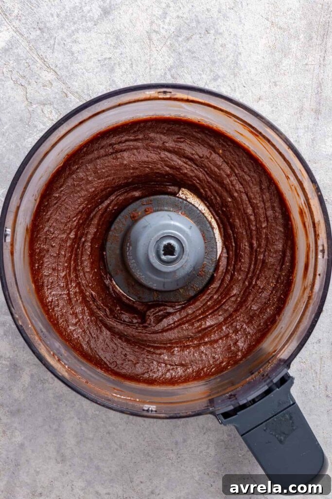 Freshly blended healthy chocolate frosting in a food processor before chilling