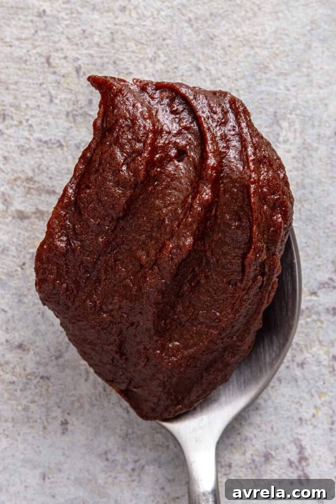 Thick homemade healthy chocolate frosting on a spoon