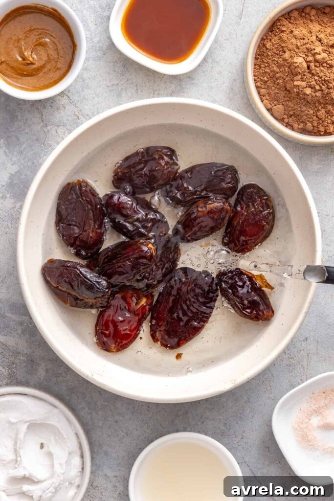 Pouring hot water over Medjool dates in a bowl for a healthy date frosting recipe