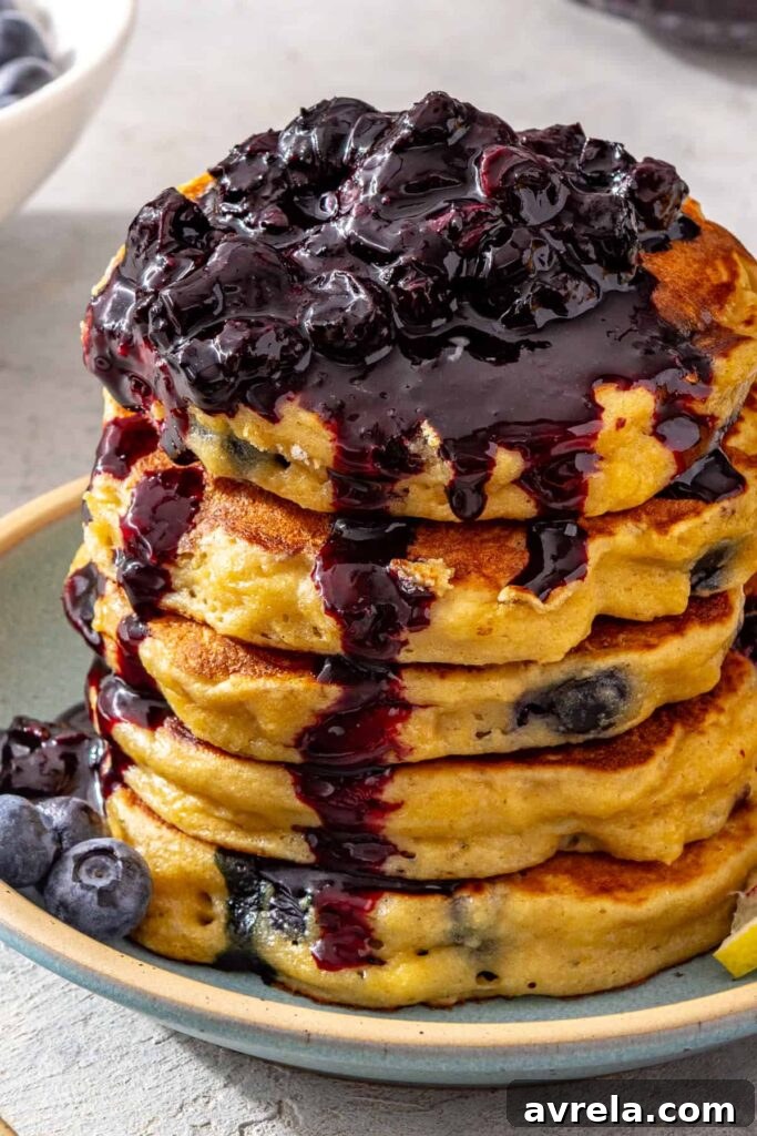 Blueberry cottage cheese pancake stack with spoonful of blueberry honey compote