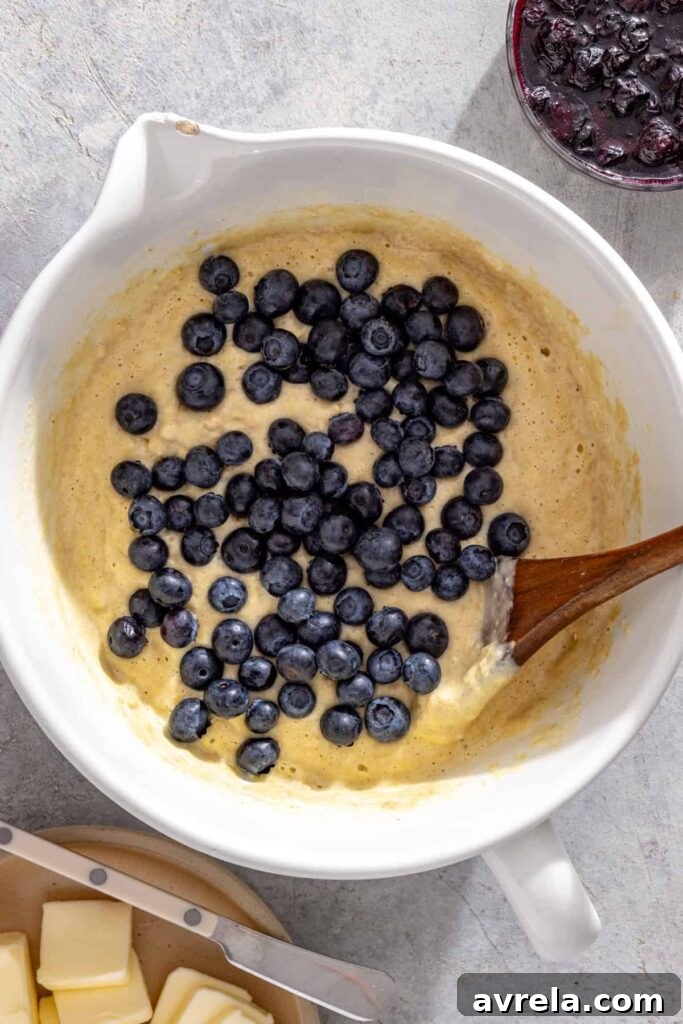 Fresh blueberries being folded into batter for lemon blueberry pancakes