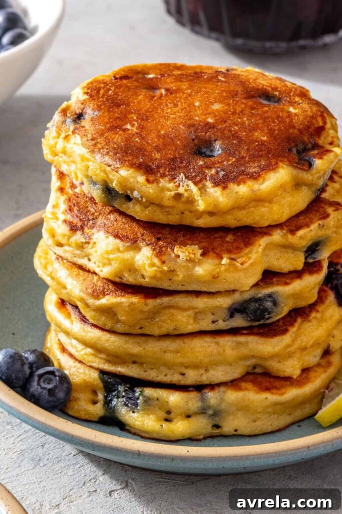 Stack of fluffy lemon blueberry cottage cheese pancakes served with fresh blueberries