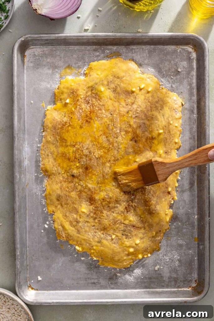 Brushing the second side of the chicken cutlet with egg wash