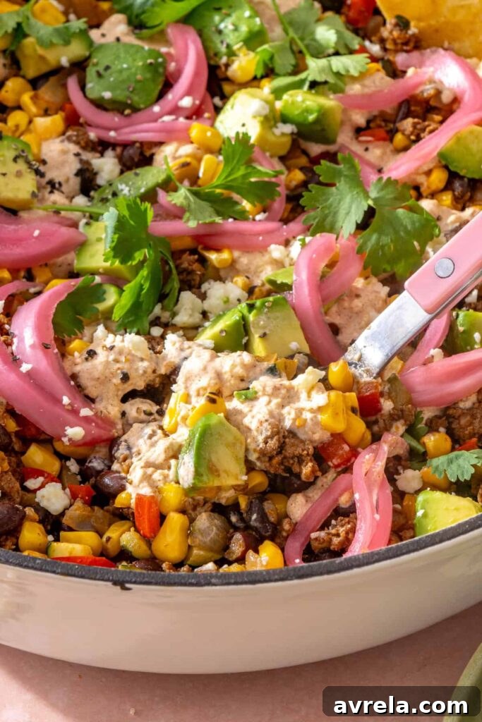 High-Protein Street Corn Taco Skillet One-Pan Dinner 15 Close-up of street corn taco skillet showing seasoned beef, black beans, fire-roasted corn, vegetables, and creamy cotija sauce