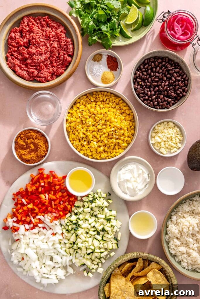 High-Protein Street Corn Taco Skillet One-Pan Dinner 7 Ingredients for street corn taco skillet including ground beef, black beans, fire-roasted corn, zucchini, bell pepper, onion, Greek yogurt, cotija cheese, and lime