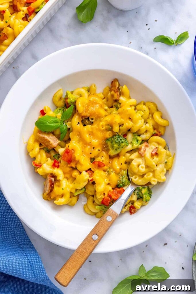 Overhead bowl of creamy broccoli cheddar pasta with broccoli and chicken sausage