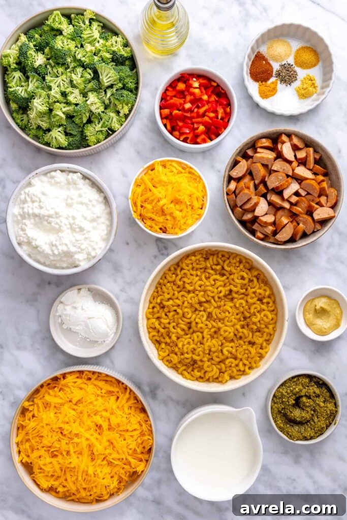 Ingredients for gluten-free broccoli cheddar pasta including cottage cheese, cheddar, broccoli, pasta, chicken sausage, red bell pepper and pesto