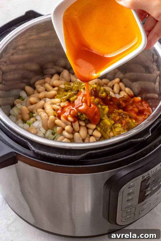 hot sauce added to an Instant Pot for a high-protein buffalo chicken chili recipe