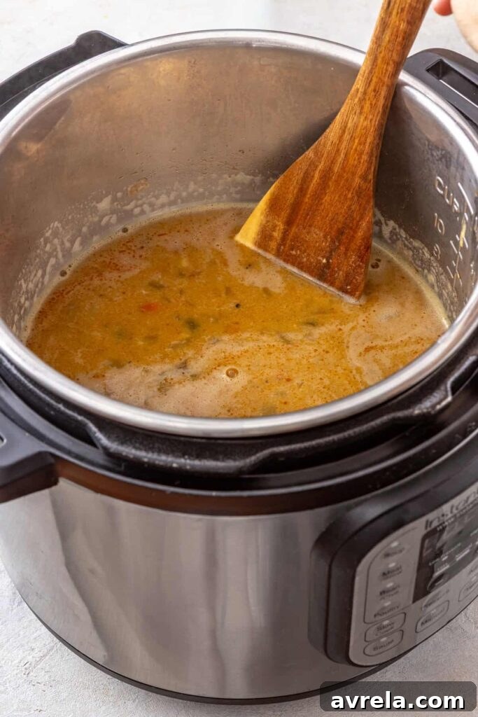 stirring the blended base of a buffalo chicken chili before adding the shredded chicken back in to the Instant Pot