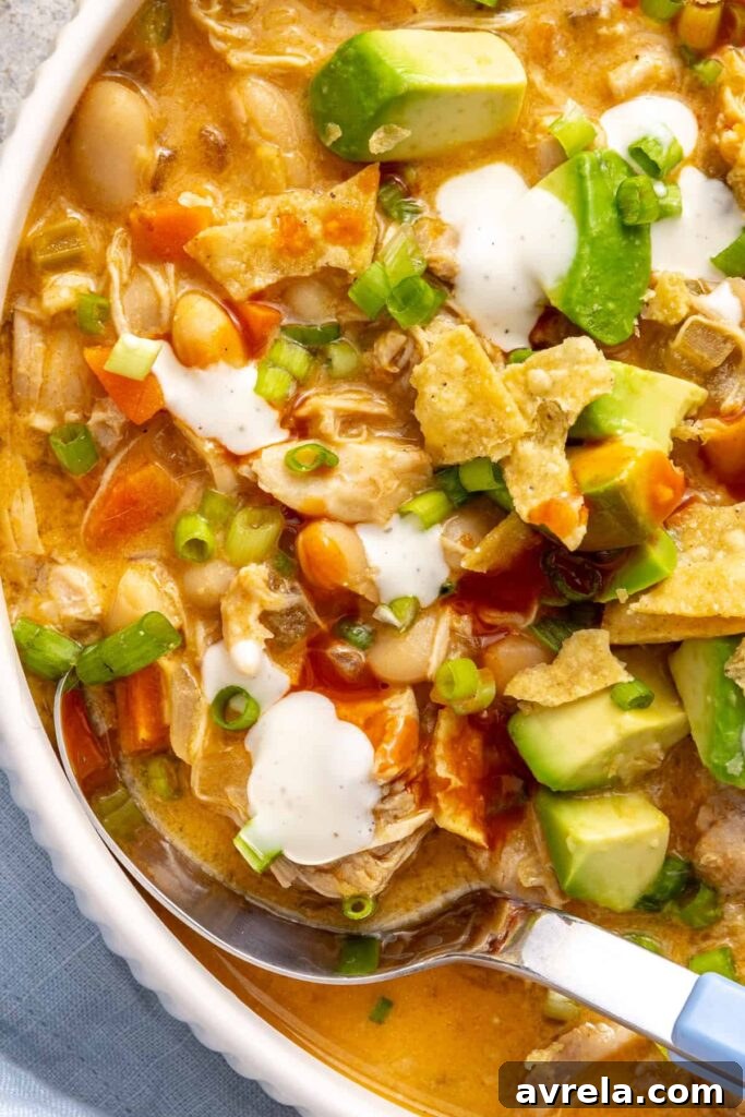 Close-up bowl of creamy buffalo chicken chili showing shredded chicken, beans and vegetables