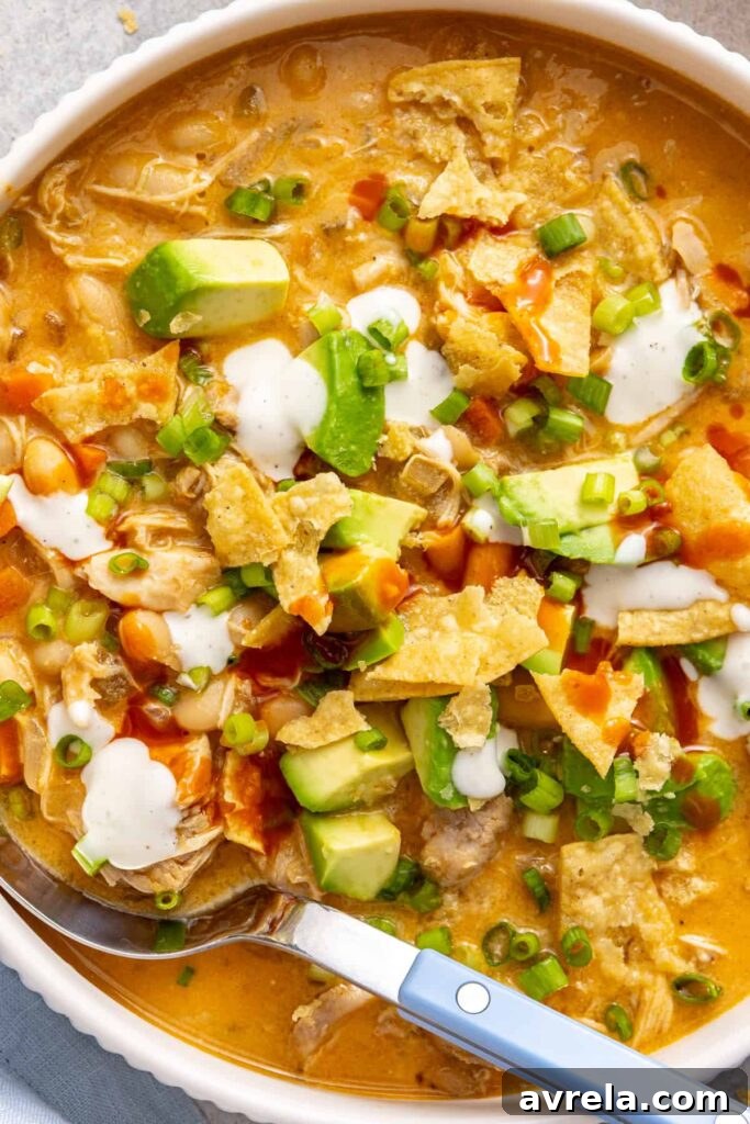 Buffalo chicken chili topped with avocado, green onion, ranch and buffalo sauce