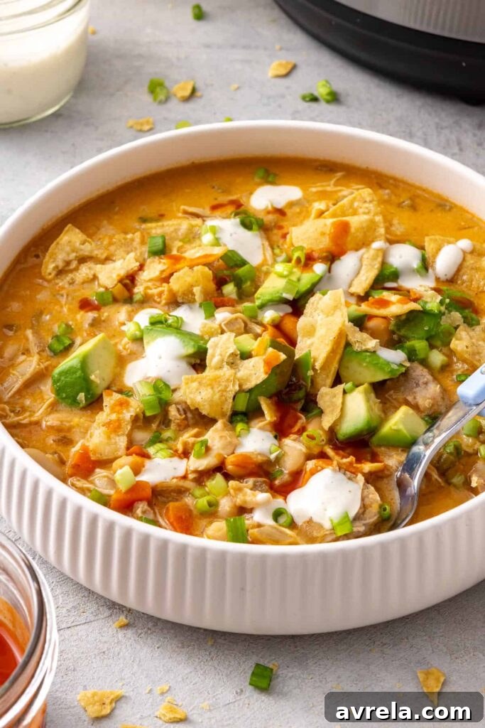 Garnished bowl of Instant Pot buffalo chicken chili served with a spoon