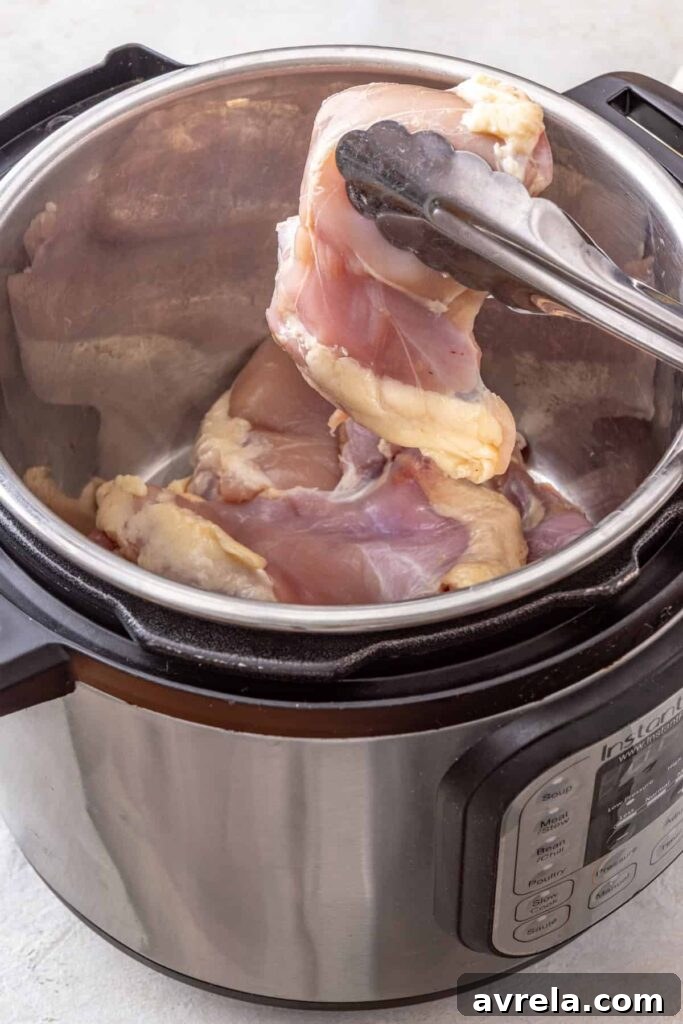 adding chicken thighs to an Instant Pot for buffalo chicken chili