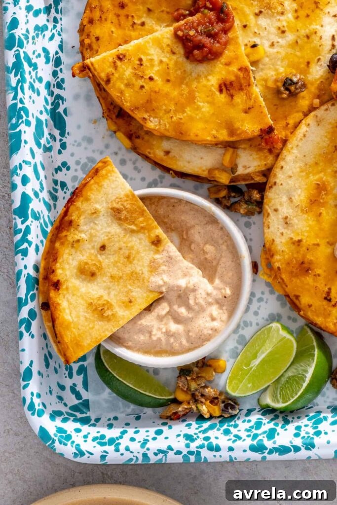 Sheet pan quesadilla wedge dipped into leftover street corn sauce with lime