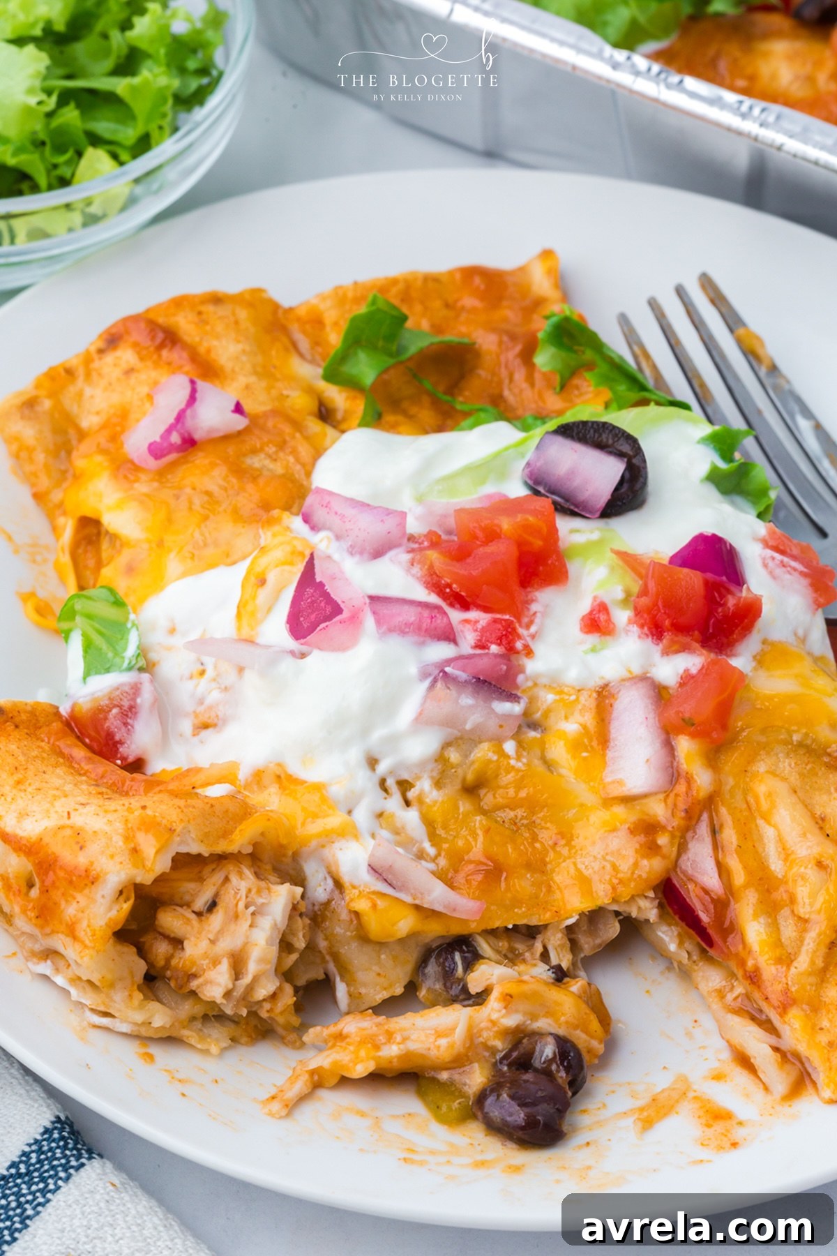 These Freezer Chicken Enchiladas make busy-night dinners so much easier! Crockpot chicken, black beans, green chiles, red enchilada sauce, and plenty of melted cheese come together in a recipe that makes TWO pans. Bake one tonight and freeze one for later!